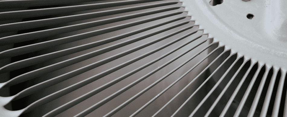 Close-up view of a radial arrangement of metal fan blades with a central circular hub.