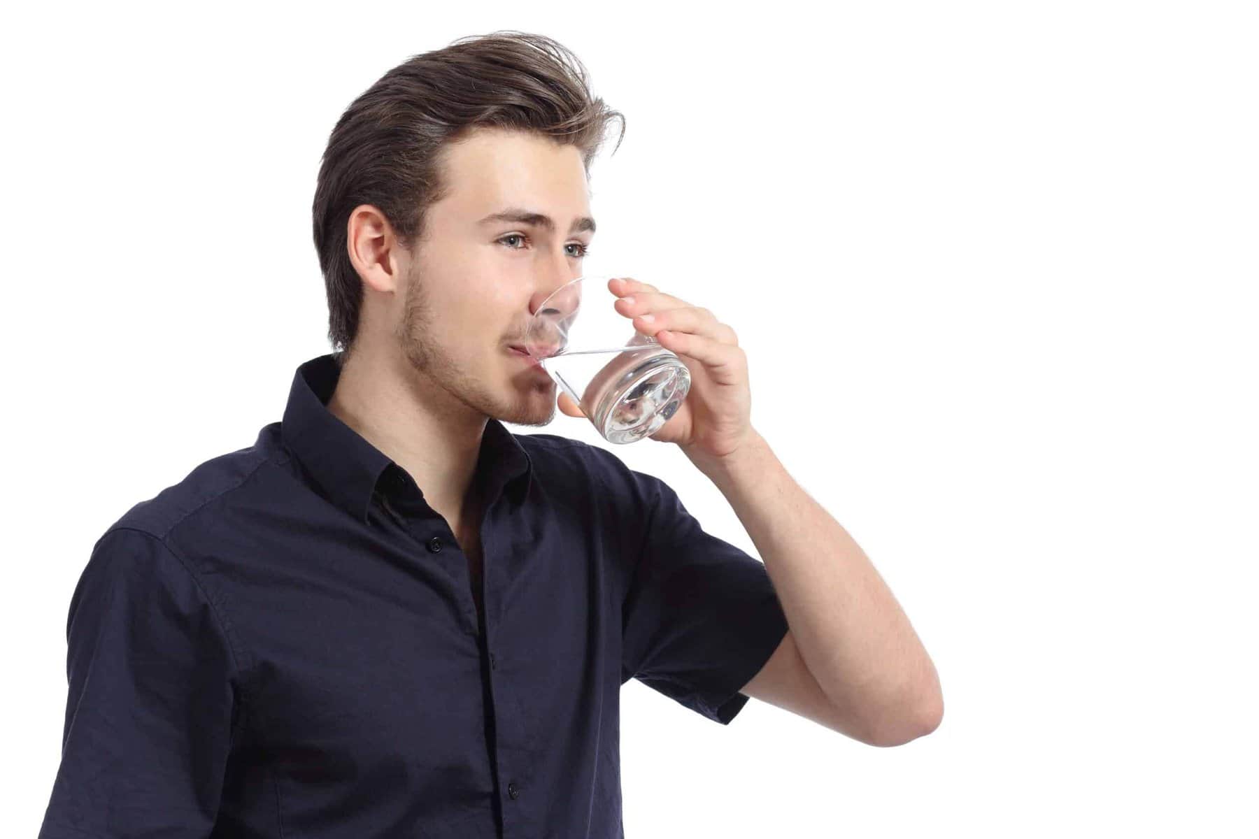 A person in a navy shirt drinks water from a glass. The background is white.