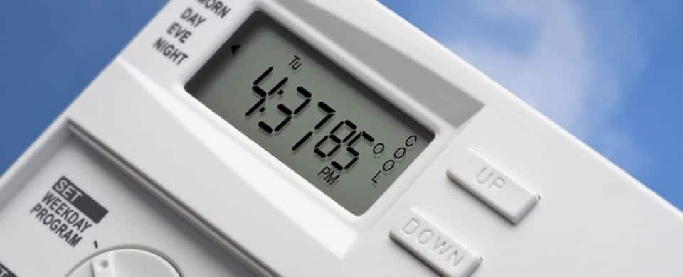 Close-up of a digital thermostat set to 85 degrees Fahrenheit at 4:37 PM, with buttons labeled "Up" and "Down" on a white background.